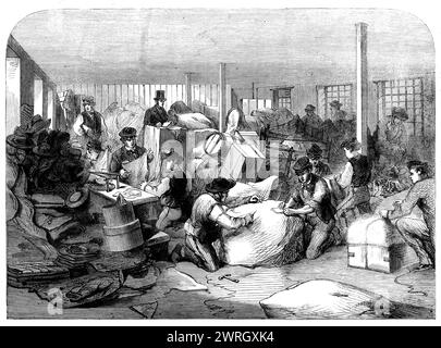 The Cotton Hunger: Die Herstellung von Kleidungsstücken in der Industrieinstitution Manchester, 1862. "Unser Künstler hat eine Skizze von dem Teil des Gebäudes angefertigt, in dem die Ballen in Manchester empfangen werden, der der Herstellung der Kleiderpakete gewidmet ist, die in der Stadt [an arbeitslose Textilarbeiter von Lancashire] verteilt werden sollen. Der Earl of Ducie hat dem Exekutivkomitee das gesamte neue Lagerhaus in der New Cannon-Street bis Juni nächsten Jahres zur Verfügung gestellt, wo die Sortier- und Verpackungsarbeit zwölf Männer beschäftigt. Jedes Paket, das nicht speziell vom Dono zugewiesen wurde Stockfoto