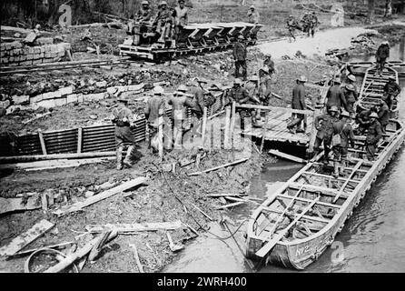 Britische Beladung von Pontonbooten mit Munition, 22. April 1917. Britische Royal Artillery-Schützen beladen Pontonboote auf dem Fluss Scarpe mit Granaten in der Nähe einer leichten Eisenbahnlokomotive, die an der Strecke nahe Saint-Laurent-Blangy, Frankreich, vorbeifuhren, 22. April 1917 während der Schlacht von Arras im Ersten Weltkrieg Stockfoto