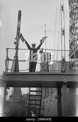 Junior Naval Scout auf U.S.S. Recruit, 1917. Eine Junior Naval rekrutiert eine Semaphore-Flagge, die auf der U.S.S. Recruit signalisiert, einem gefälschten Schlachtschiff, das von der Navy auf dem Union Square gebaut wurde, um Seeleute zu rekrutieren und Liberty Bonds während des Ersten Weltkriegs zu verkaufen Stockfoto