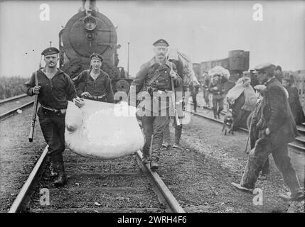 Deutsche Hilfe bei der Rückkehr nach Antwerpen, 1914. Deutsche Soldaten auf Bahngleisen mit Bundle für belgische Flüchtlinge in Antwerpen, Belgien während des Ersten Weltkriegs Stockfoto