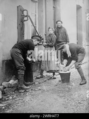 Tommy Atkins bei Etaples, zwischen 1914 und 1915. Zwei britische Soldaten namens „Tommys“, die einigen Anwohnern während des Ersten Weltkriegs bei einer Wasserpumpe, E&#xb4;taples, Frankreich, helfen Stockfoto