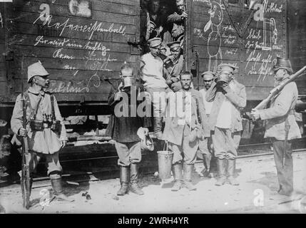 In Ostpreußen--russische Gefangene, 1914. Russische Gefangene standen an einem Eisenbahnwagen, tranken aus großen Bechern während des Ersten Weltkriegs Stockfoto