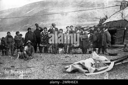 Preobrazhenie Bay: Chukchi vor ihrem Haus, in traditioneller nationaler Pelzkleidung, Kamleikas, 1910–1929. Aus einem Album mit 296 Werken, das einen Einblick in das Leben im russischen Fernen Nordosten im ersten Drittel des 20. Jahrhunderts bietet. Es umfasst Naturszenen von Kamtschatka, Ansichten von Petropawlowsk und anderen Bevölkerungszentren und Bilder der indigenen Völker Kamtschatkas und der benachbarten Gebiete - ihre Berufe und ihre materielle Kultur. Kamtschatka Regional Unified Museum Stockfoto