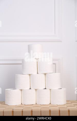 Pyramide von Toilettenpapierrollen auf dem Korbtisch Stockfoto