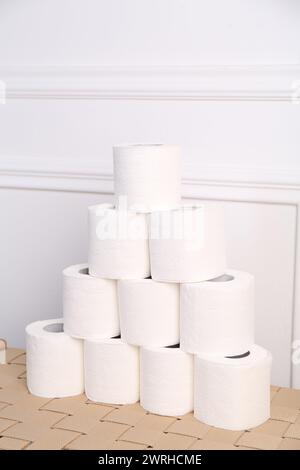 Pyramide von Toilettenpapierrollen auf dem Korbtisch Stockfoto