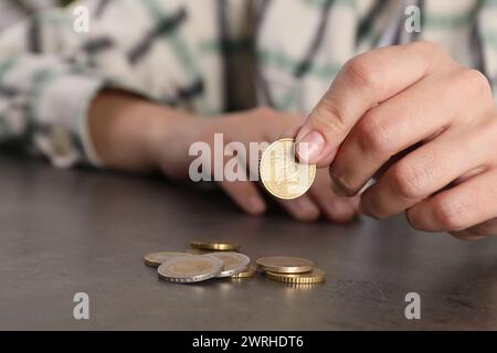 Die arme Frau zählt Münzen am grauen Tisch, Nahaufnahme Stockfoto