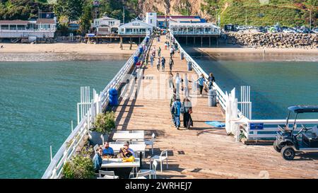 Malibu Pier, Hochwinkelansicht. Pier in Malibu, Kalifornien, an einem sonnigen Sommertag mit Touristen, die auf der Promenade entlang der Küste spazieren gehen. Stockfoto