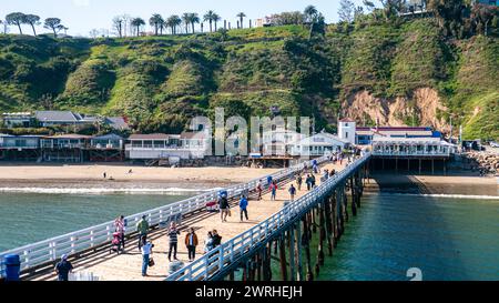 Malibu Pier, Hochwinkelansicht. Pier in Malibu, Kalifornien, an einem sonnigen Sommertag mit Touristen, die auf der Promenade entlang der Küste spazieren gehen. Stockfoto
