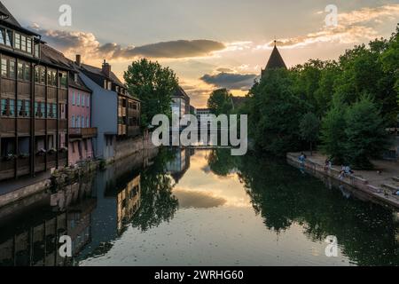 Dies ist ein Blick auf den Sonnenuntergang der Pegnitz mit traditionellen deutschen Gebäuden am Flussufer am 15. August 2022 in Nürnberg Stockfoto