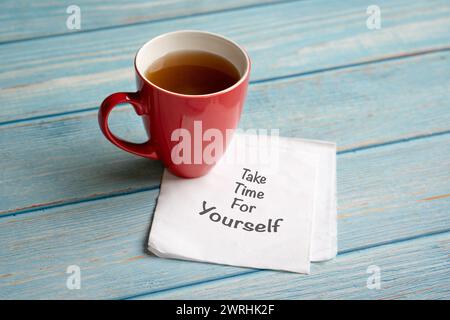 Nehmen Sie sich Zeit für sich, Worte auf Serviette neben einer Tasse Kaffee. Selbstpflegekonzept. Stockfoto