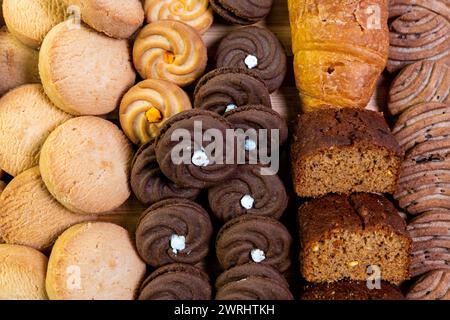 Dieses köstliche Bild zeigt eine verlockende Auswahl an Backwaren, die auf einem rustikalen Holzbrett angeordnet sind, um eine schöne Nahaufnahme zu ermöglichen. Stockfoto