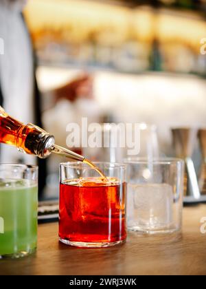 Barkeeper, der Negroni-Cocktail an der Bar zubereitet. Klassischer Negroni-Cocktail und Gin-Kurzgetränk mit süßem Wermut, rotem Bitterlikör Stockfoto