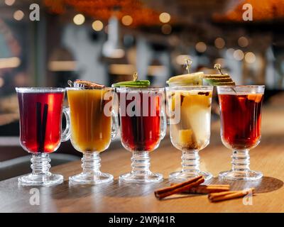 Verschiedene Geschmacksrichtungen Glühwein und Glühwein an der Bar im Hintergrund des Restaurants. Warmes Getränk für die kalte Jahreszeit. Saisonales Getränk im Herbst oder Weihnachten Stockfoto