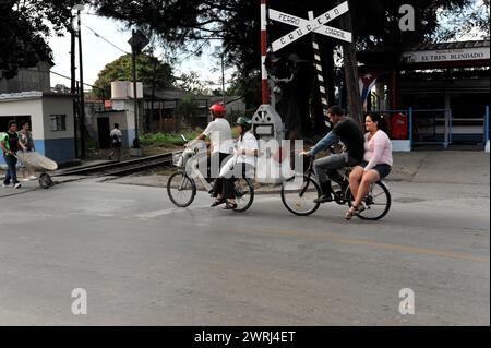 Leute auf einem Motorrad warten an einem Bahnübergang im kubanischen Alltag, Santa Clara, Kuba, Zentralamerika Stockfoto