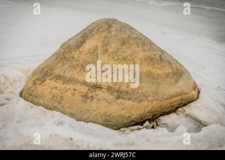 Großer dreieckiger Felsbrocken umgeben von Eis und Schnee an einem kalten Wintertag in Daejeon, Südkorea Stockfoto