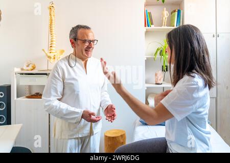 Patientin spricht mit einer erfahrenen Qi gong Masseurin und sie erklärt, wo es weh tut Stockfoto