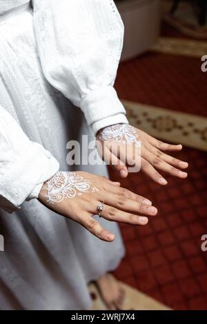 Nahaufnahme der weißen Henna-Kunst auf der Hand der Bräute Stockfoto