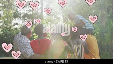 Bild der Herzen über glückliche afroamerikanische Mehrgenerationsfamilie im Garten Stockfoto