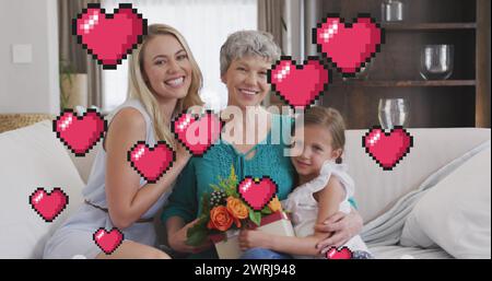 Das Bild von Herzen über glückliche Frauen der 3. Generation, die auf dem Sofa sitzen Stockfoto