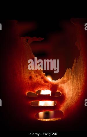 Handgemachte rote Wachskerze beleuchtet und Feuer im Innenbereich Stockfoto