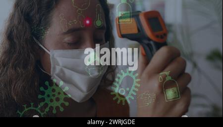 Bild der covid-19-Symbole über der Frau, die eine Gesichtsmaske trägt Stockfoto