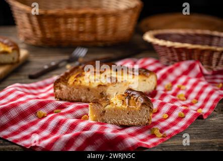 Auflaufkuchen aus Hüttenkäse mit Rosinen auf rustikaler Tischdecke Stockfoto