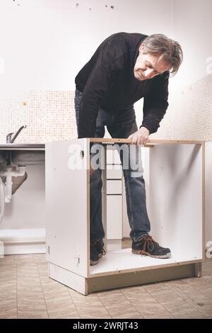 Ein älterer Mann zerlegt die Wohnküche außer Betrieb Stockfoto