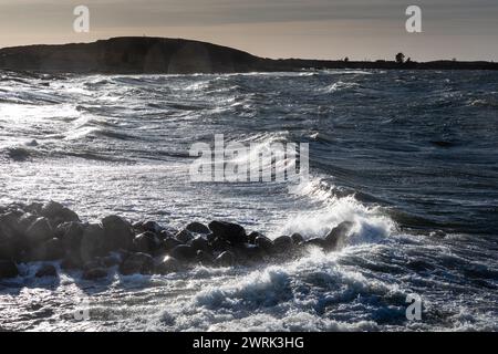 WELLEN STÜRZEN ÜBER Eine WELLENBRECHER IN JURMO, OSTSEE: Im kleinen lokalen Bootshafen auf Jurmo, einer kleinen Insel im Turku-Archipel, vor der Südwestküste Finnlands, schweben die Wellen ÜBER eine Wellenbrecher. Foto: Rob Watkins. INFO: Jurmo hat eine Bevölkerung von etwa 50 Einwohnern und ist bekannt für sein raues Gelände, seine malerische Landschaft und seine einzigartige Flora und Fauna. Jurmo ist der letzte oberirdische Teil des eiszeitlichen geologischen Salpausselkä-Gebirgssystems, das Finnland durchquert. Stockfoto