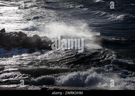 WELLEN STÜRZEN ÜBER Eine WELLENBRECHER IN JURMO, OSTSEE: Im kleinen lokalen Bootshafen auf Jurmo, einer kleinen Insel im Turku-Archipel, vor der Südwestküste Finnlands, schweben die Wellen ÜBER eine Wellenbrecher. Foto: Rob Watkins. INFO: Jurmo hat eine Bevölkerung von etwa 50 Einwohnern und ist bekannt für sein raues Gelände, seine malerische Landschaft und seine einzigartige Flora und Fauna. Jurmo ist der letzte oberirdische Teil des eiszeitlichen geologischen Salpausselkä-Gebirgssystems, das Finnland durchquert. Stockfoto