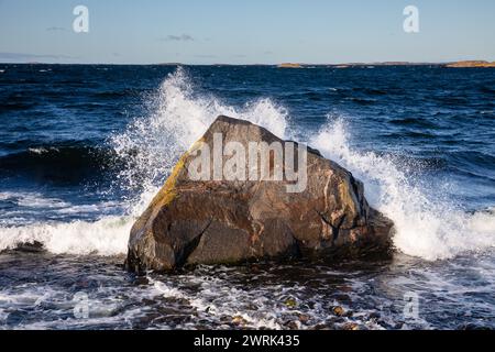 WELLEN KRACHEN AUF Einem GROSSEN EISFELSEN, der OSTSEE: Stürmische Wellen krachen auf einem großen Eisfelsen ab, der aus der letzten Eiszeit übrig geblieben ist, an einem Strand auf Jurmo, einer kleinen Insel im Turku-Archipel, vor der Südwestküste Finnlands. Foto: Rob Watkins. INFO: Jurmo hat eine Bevölkerung von etwa 50 Einwohnern und ist bekannt für sein raues Gelände, seine malerische Landschaft und seine einzigartige Flora und Fauna. Jurmo ist der letzte oberirdische Teil des eiszeitlichen geologischen Salpausselkä-Gebirgssystems, das Finnland durchquert. Stockfoto