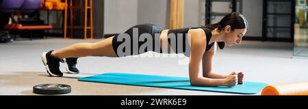 Schöne Frau mit dunklen Haaren in Sportbekleidung, die aktiv auf Fitness Matte während im Fitnessstudio, Banner Stockfoto