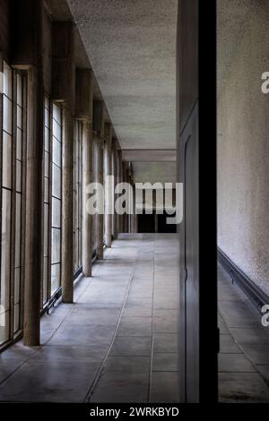 Galerie baigné de lumière par des grandes fenêtres menant à l’église, à l’intérieur du Couvent Sainte-Marie de La Tourette, construit par l’architecte Stockfoto