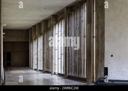 Galerie baigné de lumière par des grandes fenêtres menant à l’église, à l’intérieur du Couvent Sainte-Marie de La Tourette, construit par l’architecte Stockfoto