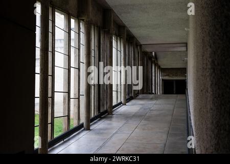 Galerie baigné de lumière par des grandes fenêtres menant à l’église, à l’intérieur du Couvent Sainte-Marie de La Tourette, construit par l’architecte Stockfoto