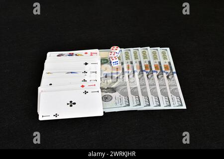 Ein Kartenspiel liegt auf dem hintereinander auf dem Spieltisch liegenden Geld. Stockfoto