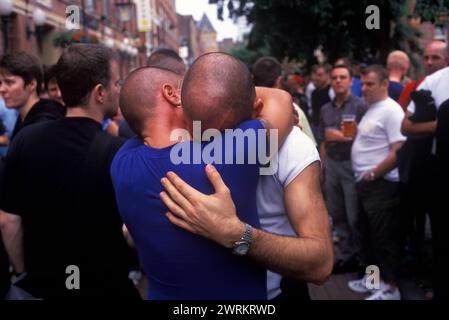 Schwule Männer teilen ihre Trauer AIDS 1990s UK. Während der jährlichen Gayfest-Parade umarmen und halten sich Männer gegenseitig und erinnern sich an Freunde, die kürzlich an AIDS gestorben sind. Manchester Pride Festival, Lancashire England 1999. HOMER SYKES Stockfoto