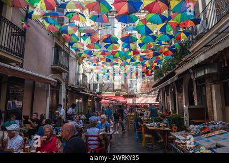 Bunte Sonnenschirme über Restaurants in der Gegend des Lebensmittelmarktes und La Pescheria Fischmarkt in der Altstadt von Catania, Sizilien, Italien Stockfoto