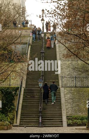 Paris, Frankreich - 17. Februar 2024 : Blick auf Touristen, die die malerischen Treppen mit Pariser Laternen im Montmartre Paris hinauf und hinuntergehen Stockfoto