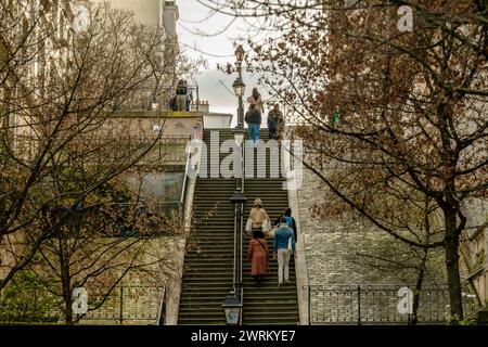 Paris, Frankreich - 17. Februar 2024 : Blick auf Touristen, die die malerischen Treppen mit Pariser Laternen im Montmartre Paris hinauf und hinuntergehen Stockfoto