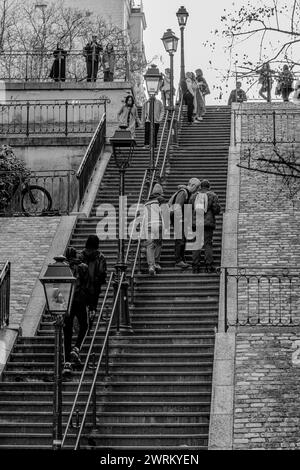 Paris, Frankreich - 17. Februar 2024 : Blick auf Touristen, die die malerischen Treppen mit Pariser Laternen im Montmartre Paris hinauf und hinuntergehen Stockfoto