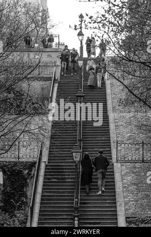 Paris, Frankreich - 17. Februar 2024 : Blick auf Touristen, die die malerischen Treppen mit Pariser Laternen im Montmartre Paris hinauf und hinuntergehen Stockfoto