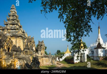 Burmesische Architektur. Gelb schimmelige Wände des Klosters Maha Aungmye Bonzan und weiße und goldene Pagoden in Inwa (Ava), Myanmar Stockfoto