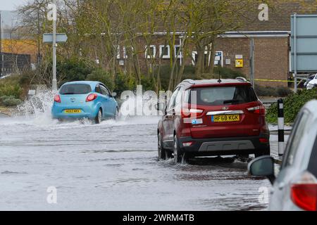 Weymouth, Dorset, Großbritannien. März 2024. Wetter in Großbritannien: Autos fahren an einem warmen, bewölkten Morgen auf der Commercial Road neben dem Hafen von Weymouth in Dorset durch das Hochwasser einer Flut. Bildnachweis: Graham Hunt/Alamy Live News Stockfoto