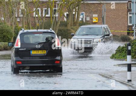 Weymouth, Dorset, Großbritannien. März 2024. Wetter in Großbritannien: Autos fahren an einem warmen, bewölkten Morgen auf der Commercial Road neben dem Hafen von Weymouth in Dorset durch das Hochwasser einer Flut. Bildnachweis: Graham Hunt/Alamy Live News Stockfoto