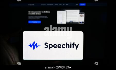 Person, die ein Mobiltelefon mit dem Logo des App-Unternehmens Speechify Inc. Vor der Webseite des Unternehmens hält. Schwerpunkt auf dem Display des Telefons. Stockfoto