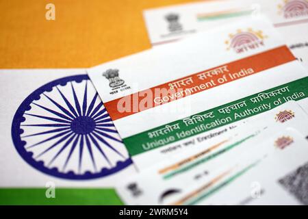 Indische Aadhaar-Karte von der Unique Identification Authority of India auf indischer Flagge Nahaufnahme Stockfoto