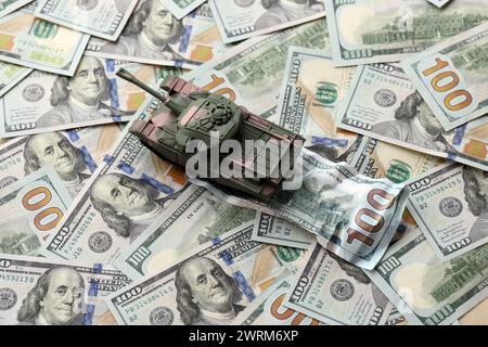 Tank auf zerknitterten 100-Dollar-Banknoten. Hintergrund der Kriegsfinanzierung und des militärischen Unterstützungspreises für die Vereinigten Staaten von Amerika Stockfoto