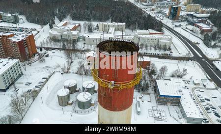 Drohnenfotografie eines großen Ziegelkamins in einem Kraftwerk während des bewölkten Wintertages Stockfoto