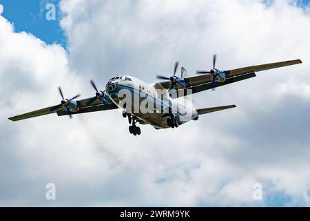 Gyor, Ungarn - 29. Juni 2023: CAVOK Air Antonov an-12 Frachtflugzeug auf dem Vorfeld des Flughafens mit Marshaller. Luftfracht und Versand. Luftfahrt und Luftfahrt. Stockfoto