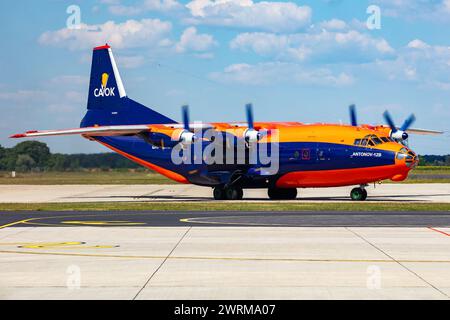 Gyor, Ungarn - 7. Juli 2023: CAVOK Air Antonov an-12 Frachtflugzeug auf dem Vorfeld des Flughafens mit Marshaller. Luftfracht und Versand. Luftfahrt und Luftfahrt. T Stockfoto